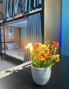 a vase of flowers sitting on a table in a bedroom at Private Sleepbox - Central Riverside in Phnom Penh