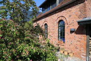 un bâtiment en briques avec des plantes en pot sur son côté dans l'établissement Ferienwohnung am Hohennauener See, à Wassersuppe