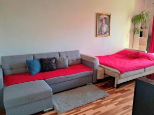 sala de estar con sofá y manta roja en Stronska, en Wroclaw
