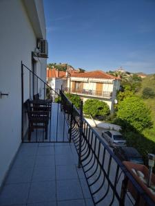 a balcony of a house with chairs and a car at Kostas Studios Apartments - Ενοικιαζόμενα δωμάτια με κουζινάκι in Myrina