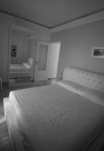 una camera con un grande letto e uno specchio di Gualtiero Camere & Suite a Caltagirone