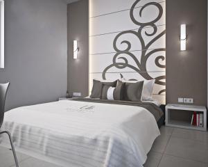 a bedroom with a large bed with a large headboard at Ungaretti Resort in Porto Cesareo