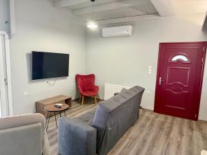 a living room with a couch and a red door at Makris Gialos Maisonette in Argostoli