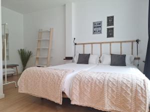 a bedroom with a large bed with white sheets and pillows at Acero y Piedra Apartamentos con jardín privado in Cerceda +76 photos