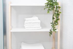 a white shelf with towels and a plant on it at Apartment Martin-nearby Krka National park in Kaočine +34 photos
