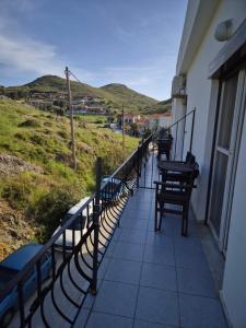 a balcony with benches and a view of a hill at Kostas Studios Apartments - Ενοικιαζόμενα δωμάτια με κουζινάκι in Mirina