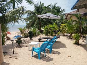 two blue chairs and an umbrella on the beach at FRONT BEACH FISHER HOUSE BANGPOR BEACH MAENAM-Koh Samui in Amphoe Koh Samui