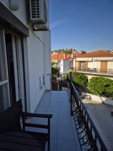 a balcony of a building with benches and a clock at Kostas Studios Apartments - Ενοικιαζόμενα δωμάτια με κουζινάκι in Myrina