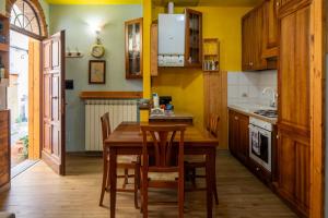 a kitchen with a wooden table and wooden cabinets at la porta di destra in Foiano della Chiana
