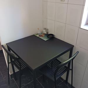 a black table and two chairs in a room at Apartments Elena & Damir in Vis