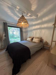 a bedroom with a bed and a chandelier at Superbe maison avec jacuzzi in Ventabren