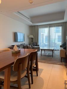 a living room with a wooden table and a couch at Address Beach Resort Fujairah Apartment by Blue World - 4 in Fujairah