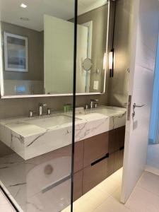 a bathroom with two sinks and a large mirror at Address Beach Resort Fujairah Apartment by Blue World - 4 in Fujairah