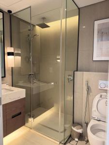 a glass shower in a bathroom with a toilet at Address Beach Resort Fujairah Apartment by Blue World - 4 in Fujairah