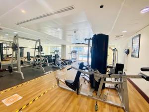 a gym with treadmills and machines in a room at What a view - very close to DMCC metro station in Dubai