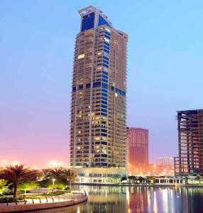 a tall building in a city next to a body of water at What a view - very close to DMCC metro station in Dubai
