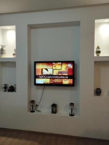 een flatscreen-tv aan een muur in een kamer bij Maison kelibia Ezzahra plage a pied in Ḩammām al Ghazzāz