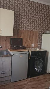 a kitchen with a washing machine and a washer at Lursmanashvili house in Itʼkhvisi
