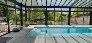a swimming pool in a house with a large window at Chambres d'Hôtes des Rouets in Fourmies