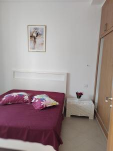 een slaapkamer met een paars bed met 2 kussens bij Maison kelibia Ezzahra plage a pied in Ḩammām al Ghazzāz
