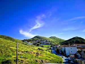 a small town on a hill with green hills at Kostas Studios Apartments - Ενοικιαζόμενα δωμάτια με κουζινάκι in Mirina +57 photos