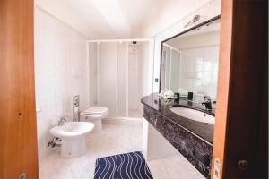 a bathroom with a sink and a toilet and a mirror at Casa Belvedere in Le Castella