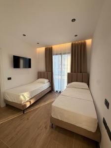 a bedroom with two beds and a tv on the wall at Hotel Imperial in Spille