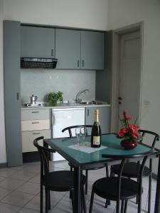 Holiday Residence في بافينو: مطبخ مع طاولة مع كراسي وزجاجة من النبيذ