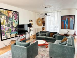 salon z 2 kanapami i telewizorem w obiekcie Maison de charme de 280m2 avec piscine chauffée … w mieście Luçon