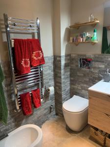 y baño con aseo y toallas rojas. en Bijoux sulle piste, en Sauze d'Oulx