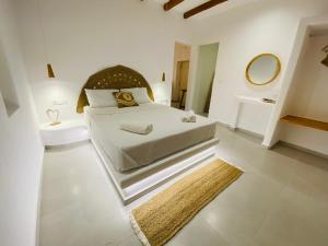 a white bedroom with a large bed and a mirror at Yannis Boutique Cycladic House in Kampos Paros +31 photos