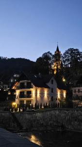 ein beleuchtetes Gebäude mit einer Kirche im Hintergrund in der Unterkunft Willa Zacisze Szczawnica 25 m2 in Szczawnica
