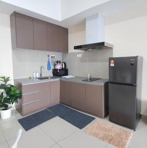 a kitchen with a refrigerator and a sink at Alinea Suites Shah Alam Seksyen 14 in Shah Alam +10 photos