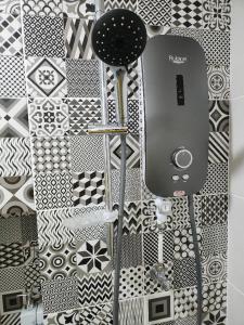 a bathroom with black and white patterns on a wall at Alinea Suites Shah Alam Seksyen 14 in Shah Alam