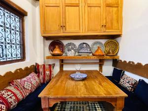 a living room with a wooden table and some plates at Charming Riad Medina View 4 AC Bedrooms Panoramic Terrace Central Fez in Fès al Bali +36 photos