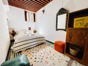 a bedroom with a bed and a mirror at Charming Riad Medina View 4 AC Bedrooms Panoramic Terrace Central Fez in Fès al Bali