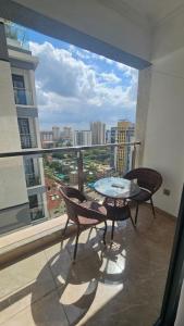 a balcony with a table and chairs and a large window at Padmore Residences - B1506 in Nairobi