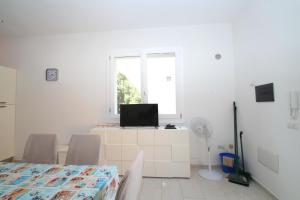 a white room with a tv and a table and a window at Palau Fonte Vecchia Apartment in Palau