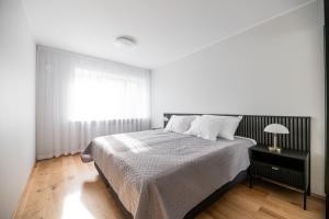 Una habitación blanca con una cama y una ventana en Centrum Apartment Nikolai, en Pärnu