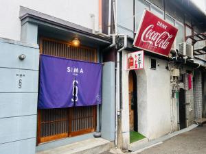 un edificio con uno striscione viola sulla facciata di SIMA inn a Onomichi