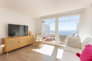 a living room with a tv and a large window at Atico espacioso con vistas panorámicas in Calahonda