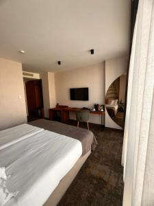 a hotel room with a bed and a television at MM Boutique Hotel in Burgas