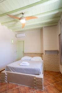 a bedroom with a bed with a ceiling fan at Villa Ostria in Koufonisia