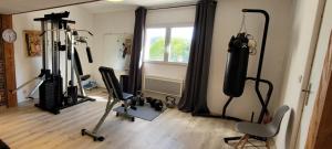 a room with a gym with several exercise equipment at Dans la nature, villa de Standing avec piscine chauffée, jaccusi extérieur in Clermont-lʼHérault