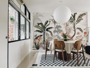 een eetkamer met een tafel en een plantenwand bij Casa Palm Spring in Bangkok +35 foto's