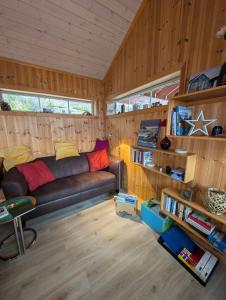 a living room with a couch in a tiny house at Hyggelig Blikk - Mountain Cabin with Sauna & Ski Access in Vradal