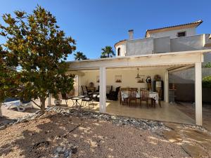 a house with a patio with a table and chairs at Maikran Premium Fantastic Family Villa with Pool in San Fulgencio