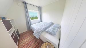 a small bedroom with a bed and a window at 2 Bedroom Apartment in Island Paradise in Sandnessjøen