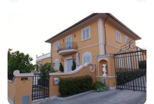 a large yellow house with a black fence at Villa Manuela in Altopascio