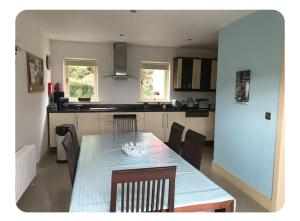 a kitchen with a table and chairs and a kitchen with at Spacious 3 bedroomed house with amazing views in Rossacoosane